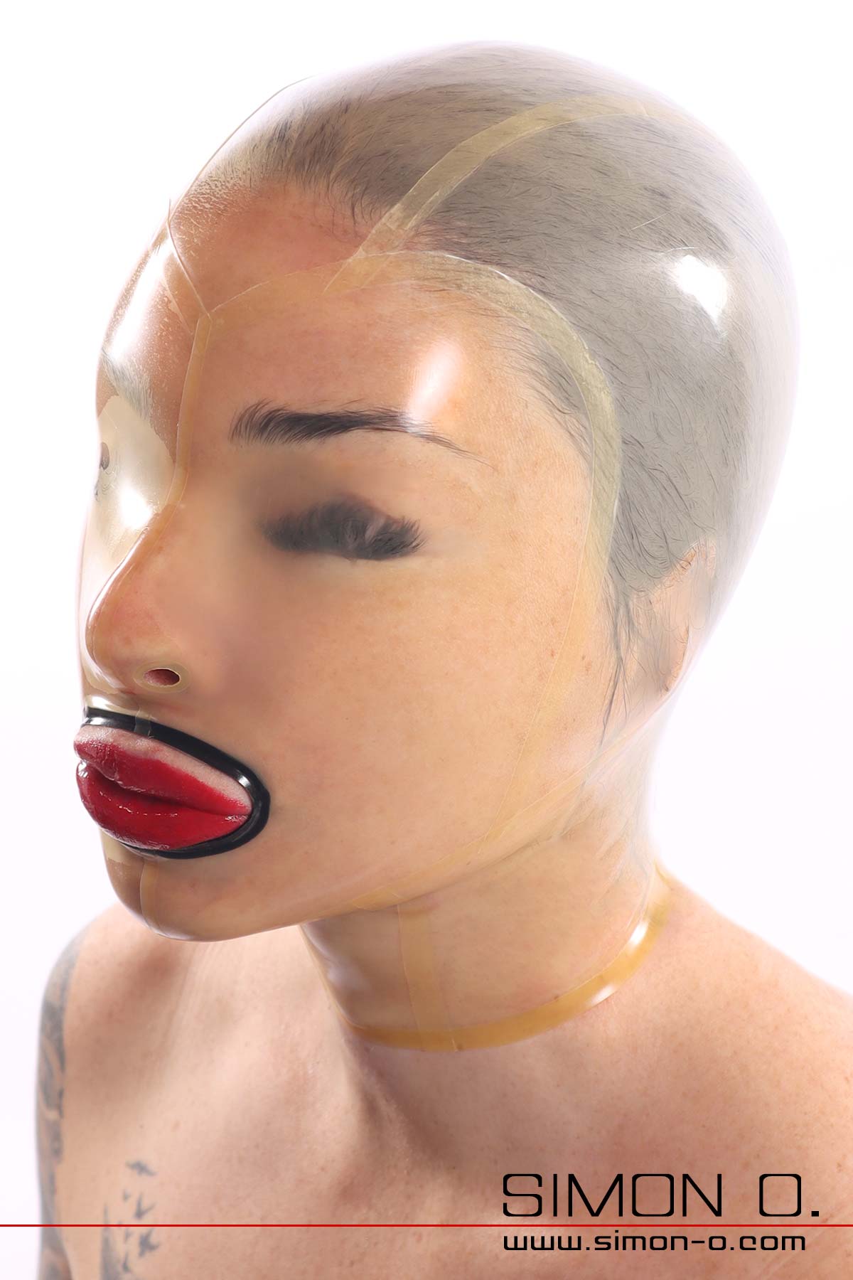 Latex mask transparent with closed eyes A transparent, shiny latex mask without eye openings fits snugly around the face of a woman with red lips.