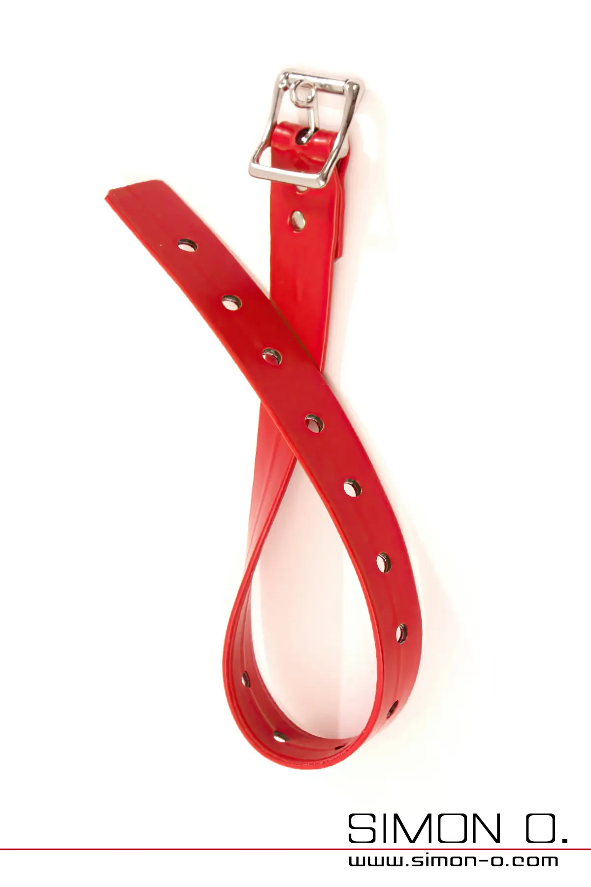 Ein roter, glänzender Latex-Fesselriemen mit Löchern und einer Metallschnalle auf weißem Hintergrund.