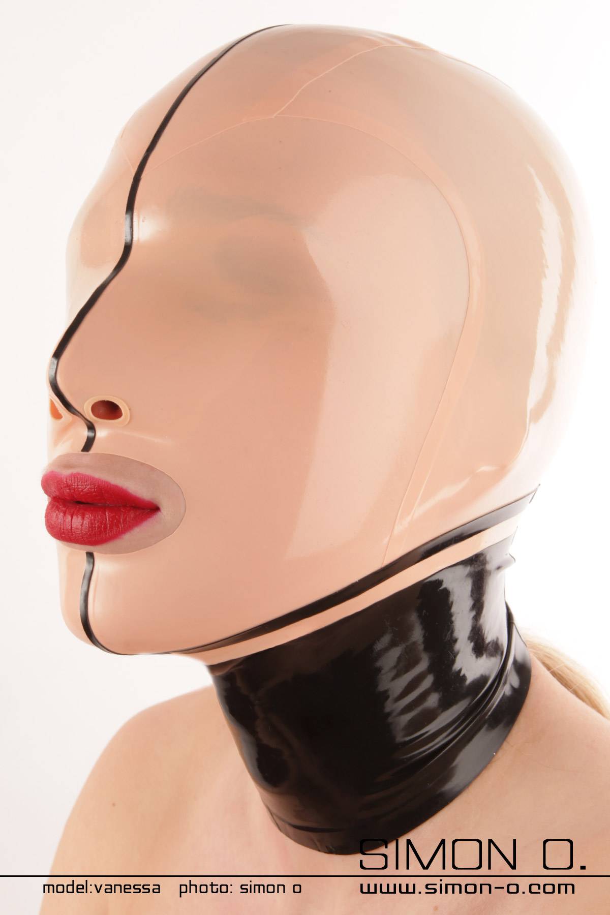 Latex Maske Nylon Face Eine Person trägt eine glänzende, eng anliegende hautfarbene Nylon Face Latexmaske mit schwarzen Kontrast Elementen.
