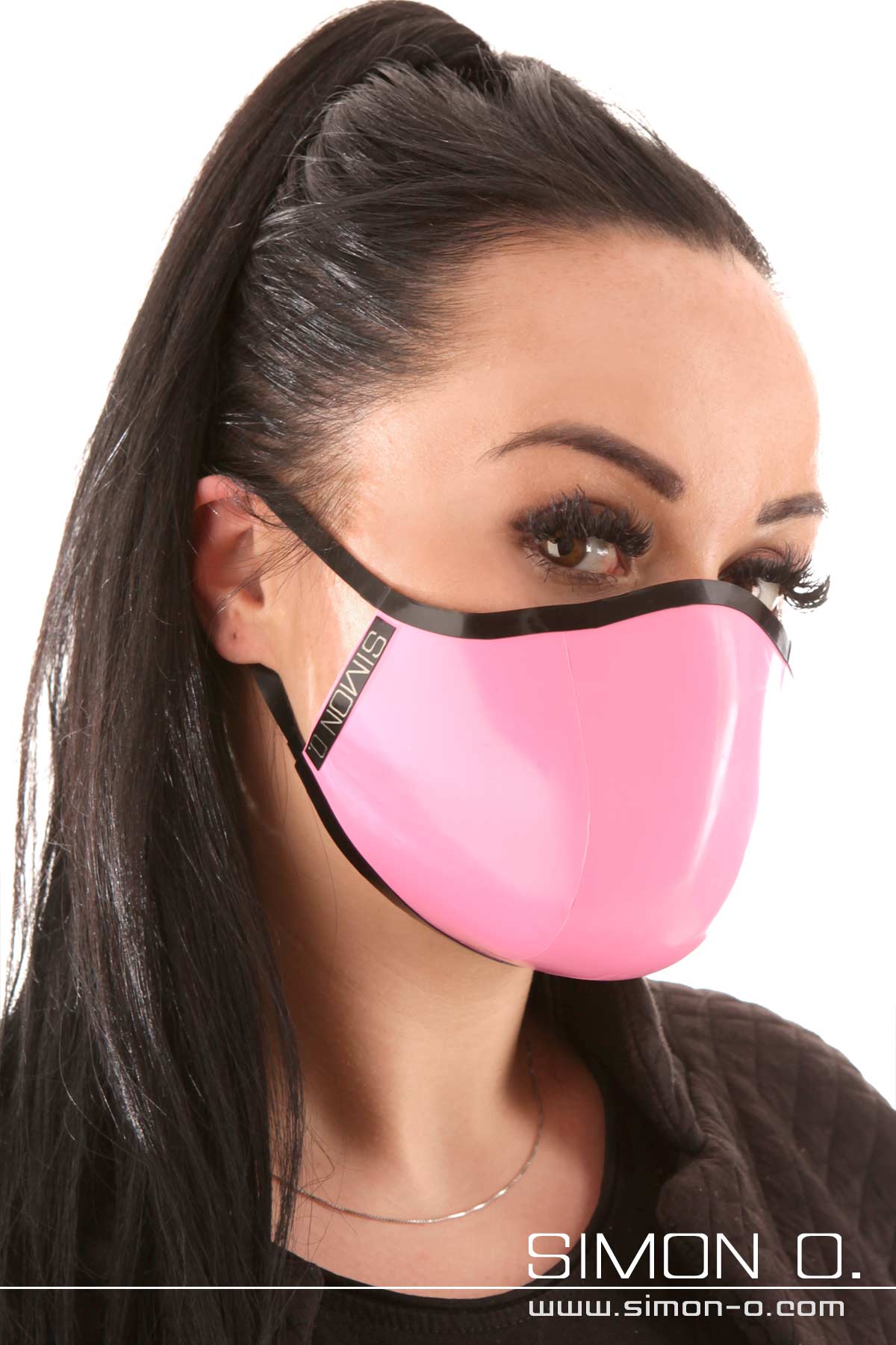 Latex Mundschutz in Pink mit Schwarz Eine dunkelhaarige Frau trägt einen Latex Mundschutz in Pink mit Schwarz