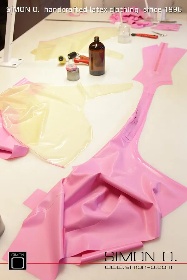 La production d'un catsuit en latex rose avec une partie transparente pour les jambes est montrée, en commençant par le découpage et le collage jusqu'au produit fini.