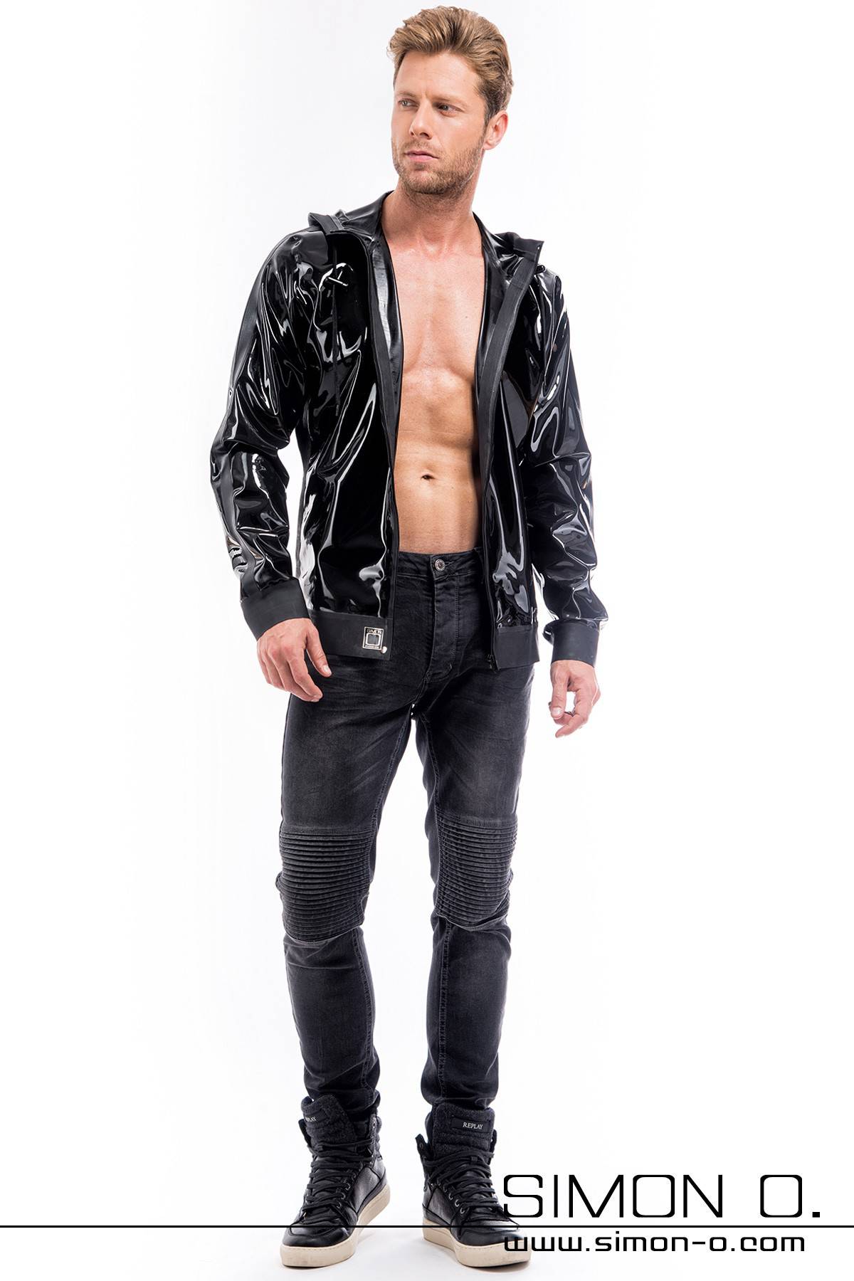 Latex jacket with hood and pockets in black A blond man wears a latex jacket with a separable zip hood and pockets in black.