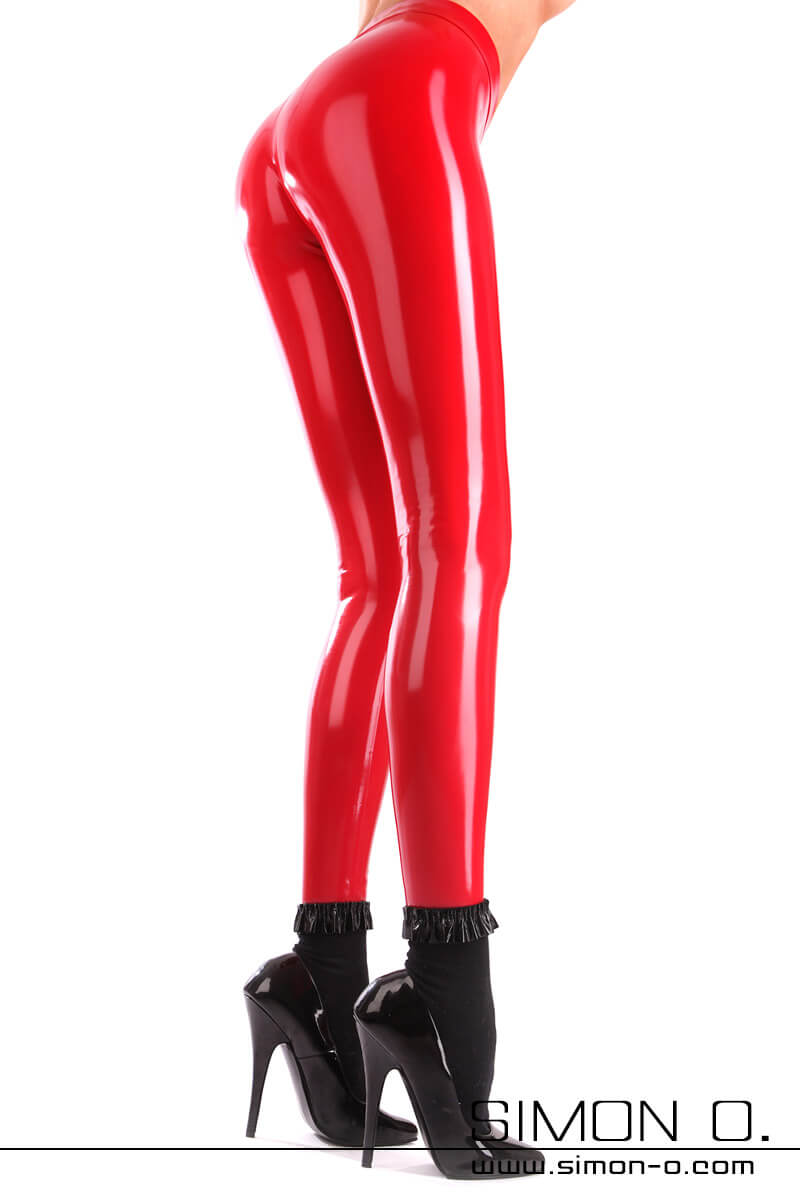 Latex Leggings für Damen Eine eng anliegende, hochglänzende Latex Leggings wird von einer schlanken Dame mit schwarzen Socken und High Heels getragen.