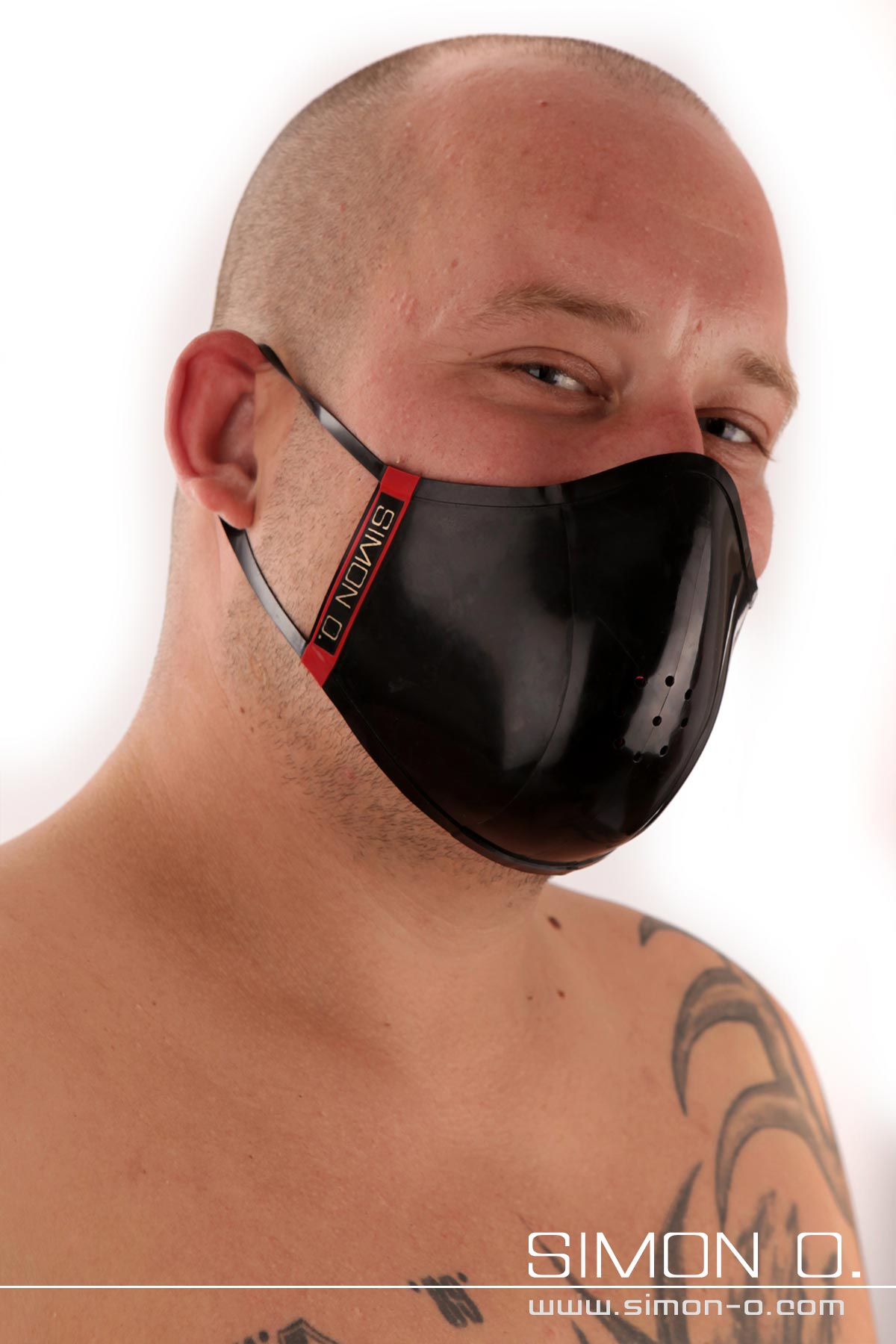 Latex Mund und Nasenschutz in Schwarz Ein Mann mit Glatze trägt einen schwarzen Mundschutz aus Latex.