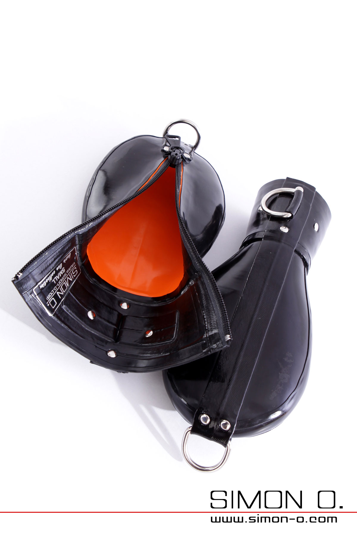 Schwarze Latex Bondage-Fäustlinge Nahaufnahme von schwarzen Bondage-Fäußtlingen aus Latex mit D-Ringen und absperrbaren Reißverschluss auf weißem Hintergrund.