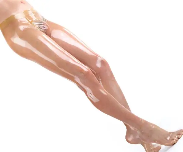 A man wears tight black shiny latex tights from the Simon O. Express production line.