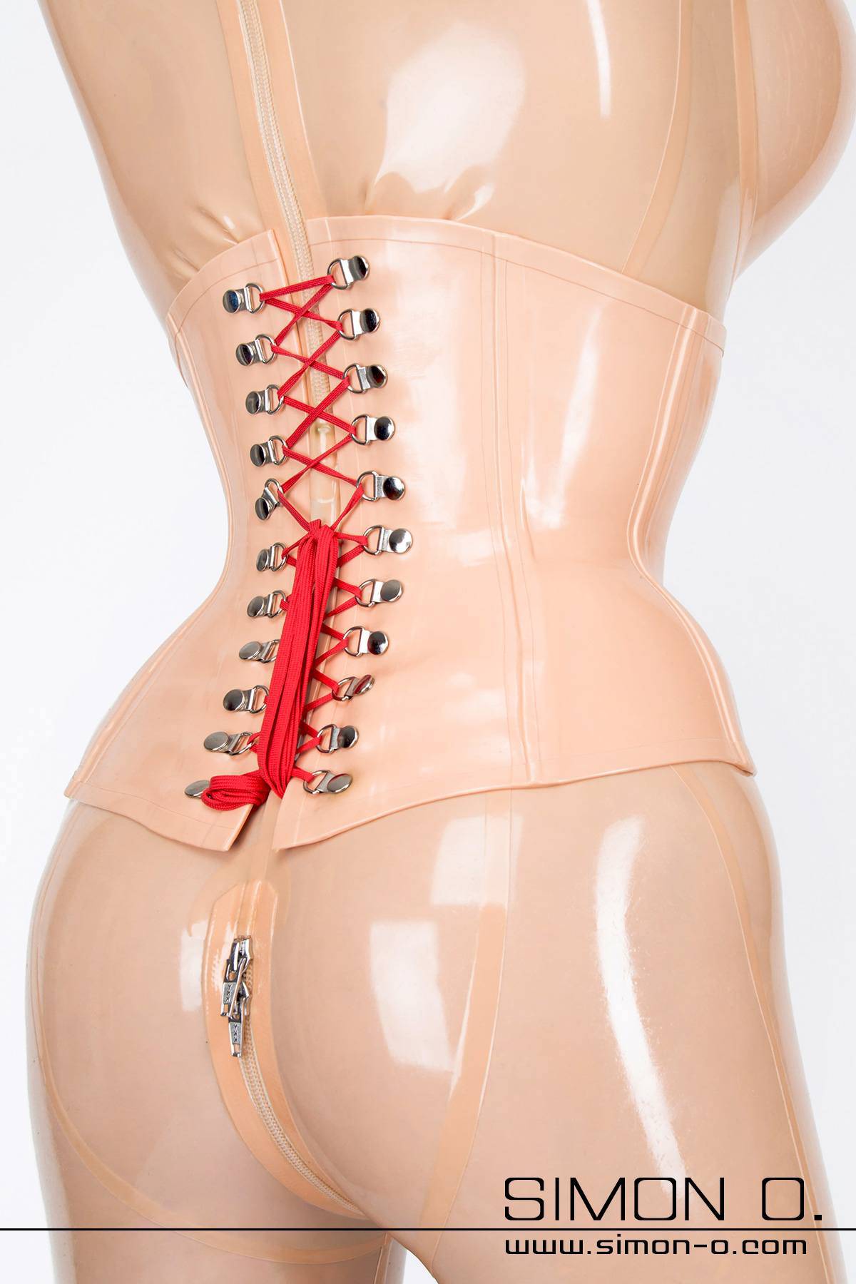 Latex corset with reinforced waistband and lacing A tightly laced latex corset in skin colour with red lacing