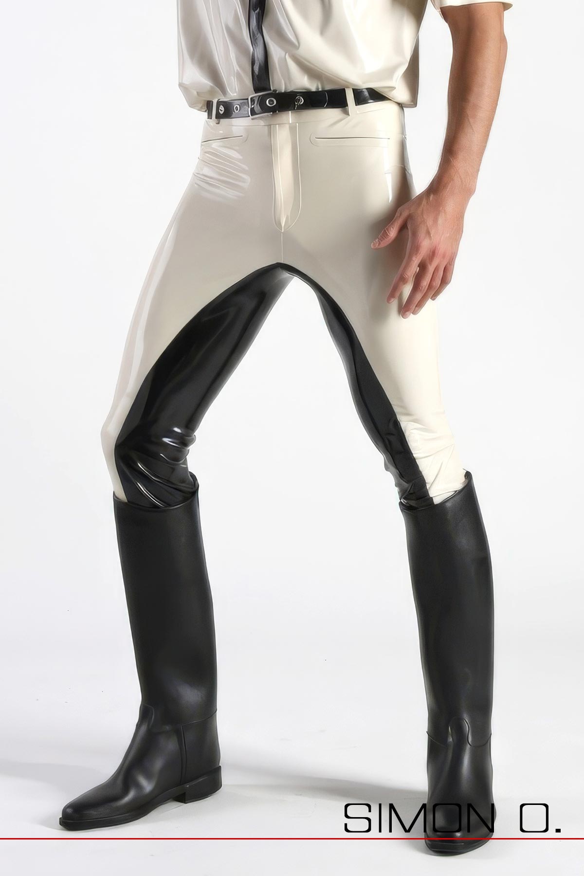 Ein Mann trägt eine schwarz weiße Latex Reithose und Reitstiefel.