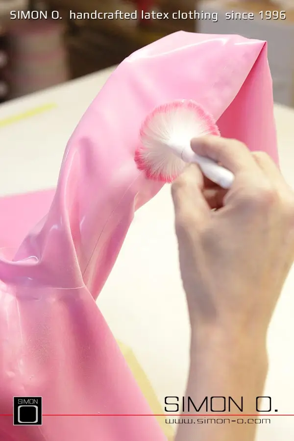 La production d'un catsuit en latex rose avec une partie transparente pour les jambes est montrée, en commençant par le découpage et le collage jusqu'au produit fini.