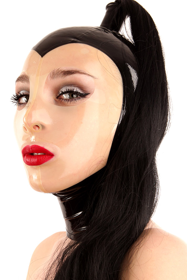 Domina Latex Maske mit Haarteil Eine Domina trägt eine enge Latexmaske mit glänzendem Finish und schwarzen Ponytail. Die Maske ist Schwarz und hat ein transparentes Gesichtsfeld. Zusammen mit kräftigem roten Lippenstift und geschwungenem Eyeliner strahlt dieser Look eine dramatische und