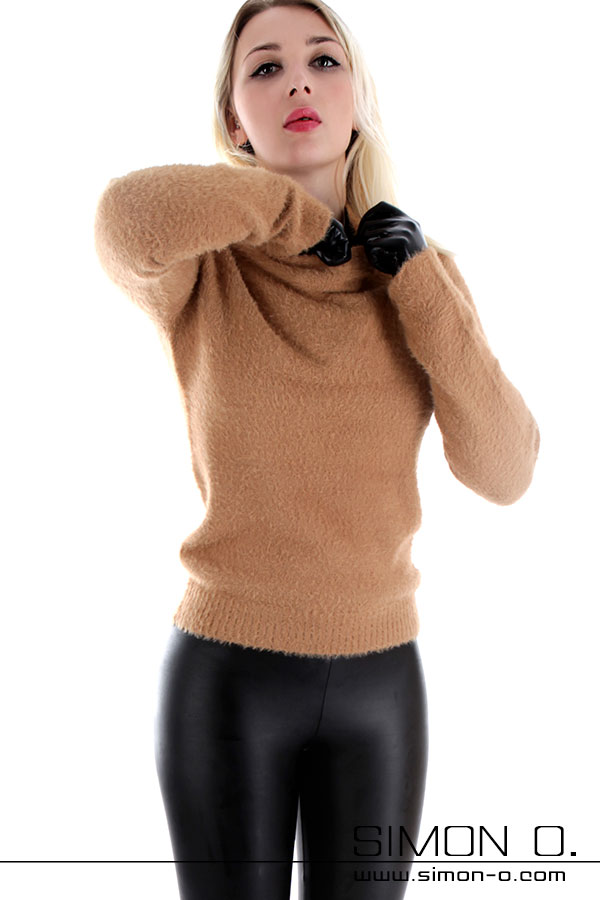 Latex unter Alltagskleidung Eine Person in einem hellbraunen, flauschigen Pullover, schwarzen Latex outfit unter der Kleidung.