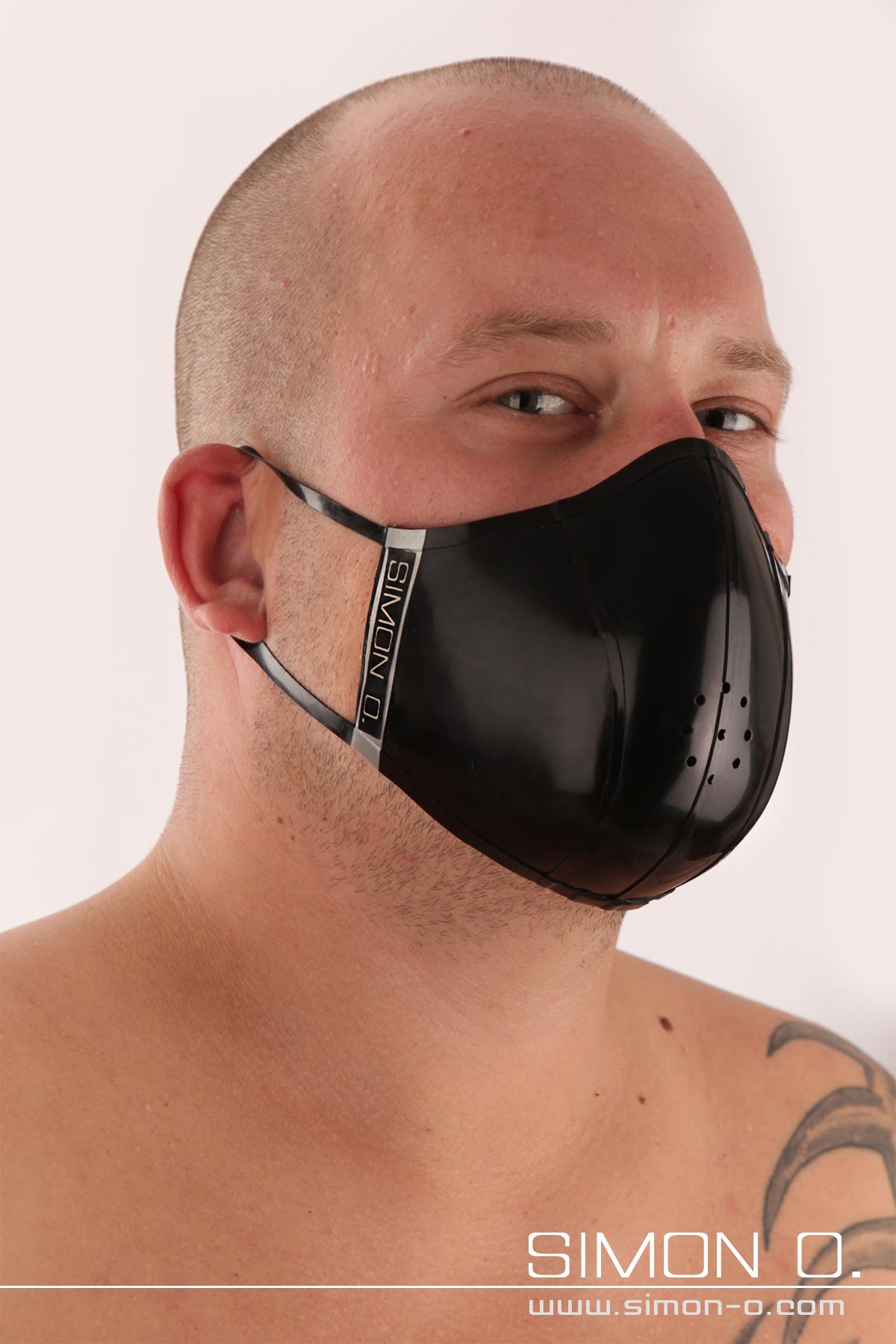 Latex Mund und Nasenschutz in Schwarz Ein Mann mit Glatze trägt einen schwarzen Mundschutz aus Latex.