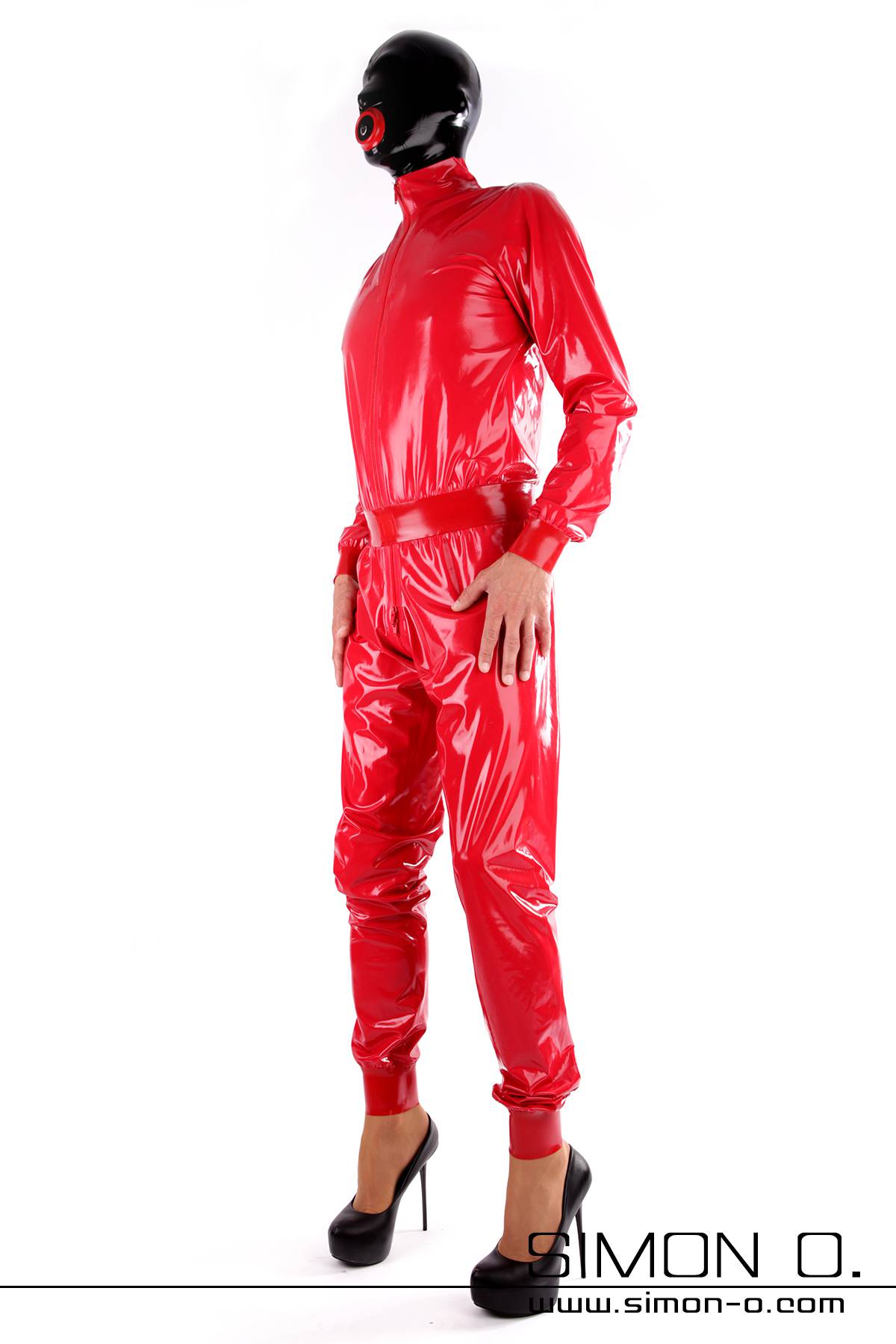 Locker geschnittener Latex Catsuit Ein Mann mit einer Latex Maske trägt einen lockeren Latex Catsuit in glänzenden Rot mit schwarzen High Heels