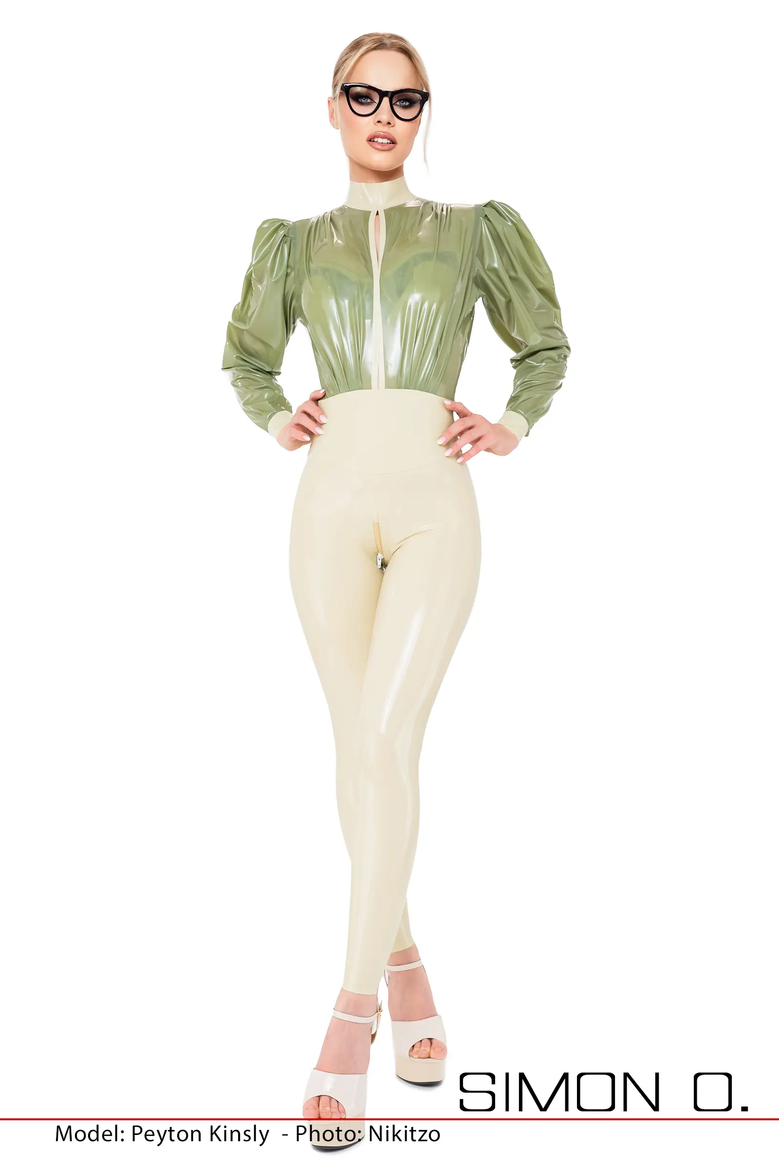Frau posiert in einem sandfarbenen Latex Catsuit mit lockeren Oberteil in grün welcher eine Öffnung im Brustbereichhat.