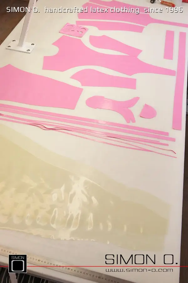La production d'un catsuit en latex rose avec une partie transparente pour les jambes est montrée, en commençant par le découpage et le collage jusqu'au produit fini.
