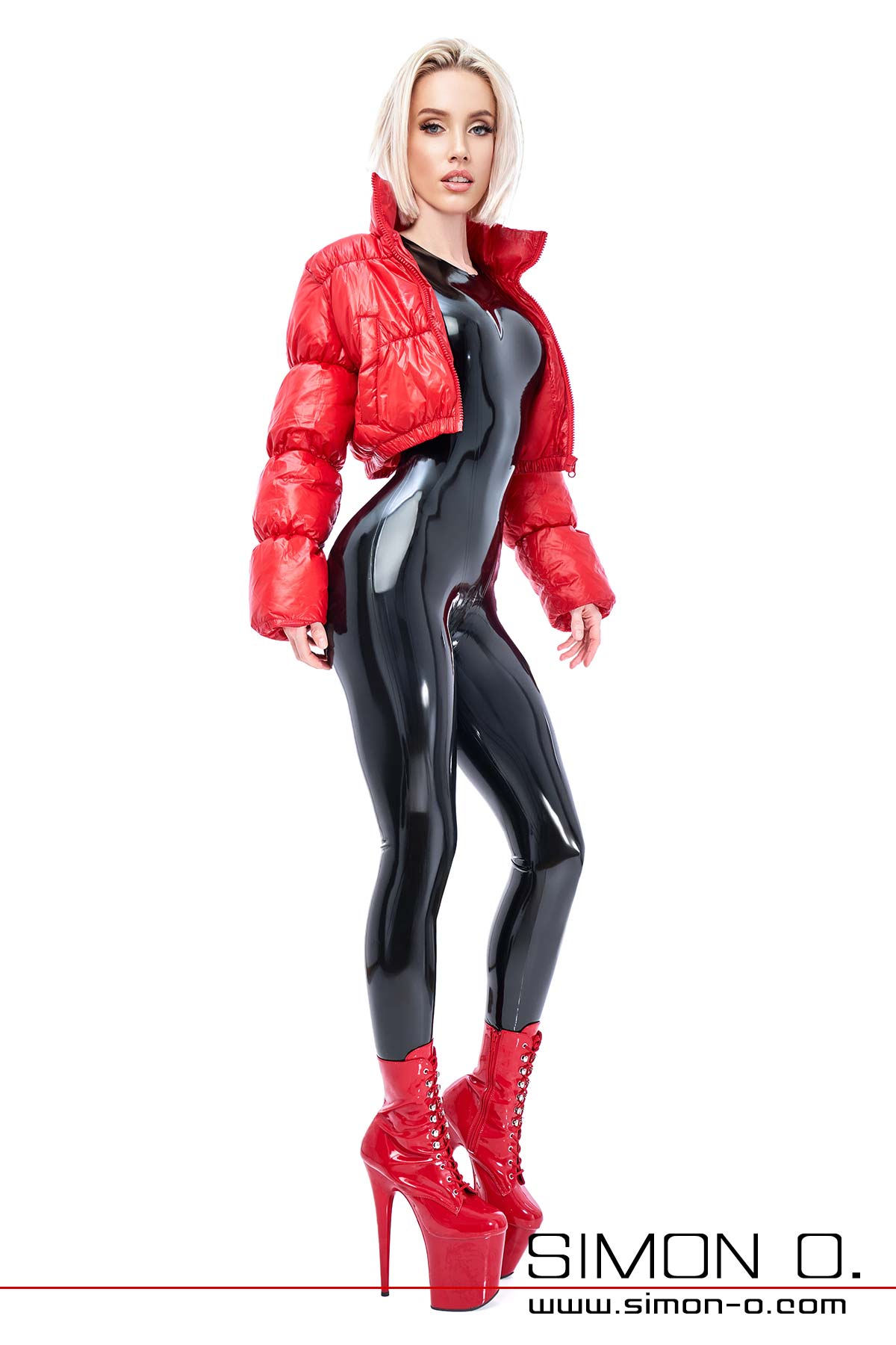 Latex catsuit and endurance jacket A sexy lady wears a shiny black latex catsuit with a red denim jacket and high heels.