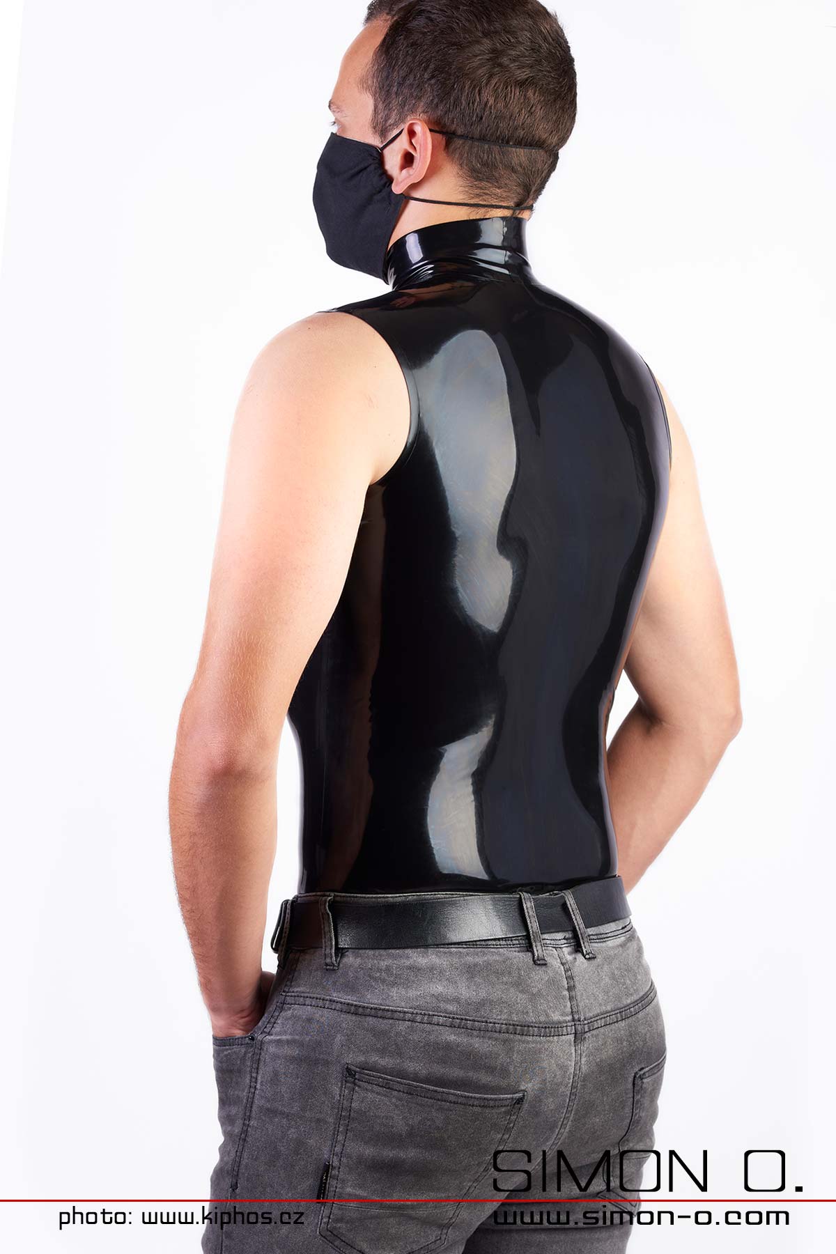 Latex shirt with stand-up collar sleeveless A man wears a tight sleeveless latex shirt in black with stand-up collar - seen from behind.