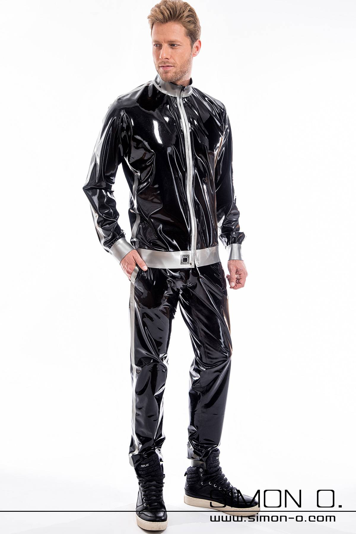 Shiny jogging suit for men made of latex A man wearing a shiny jogging pants and a latex jacket with pockets in black combined with silver