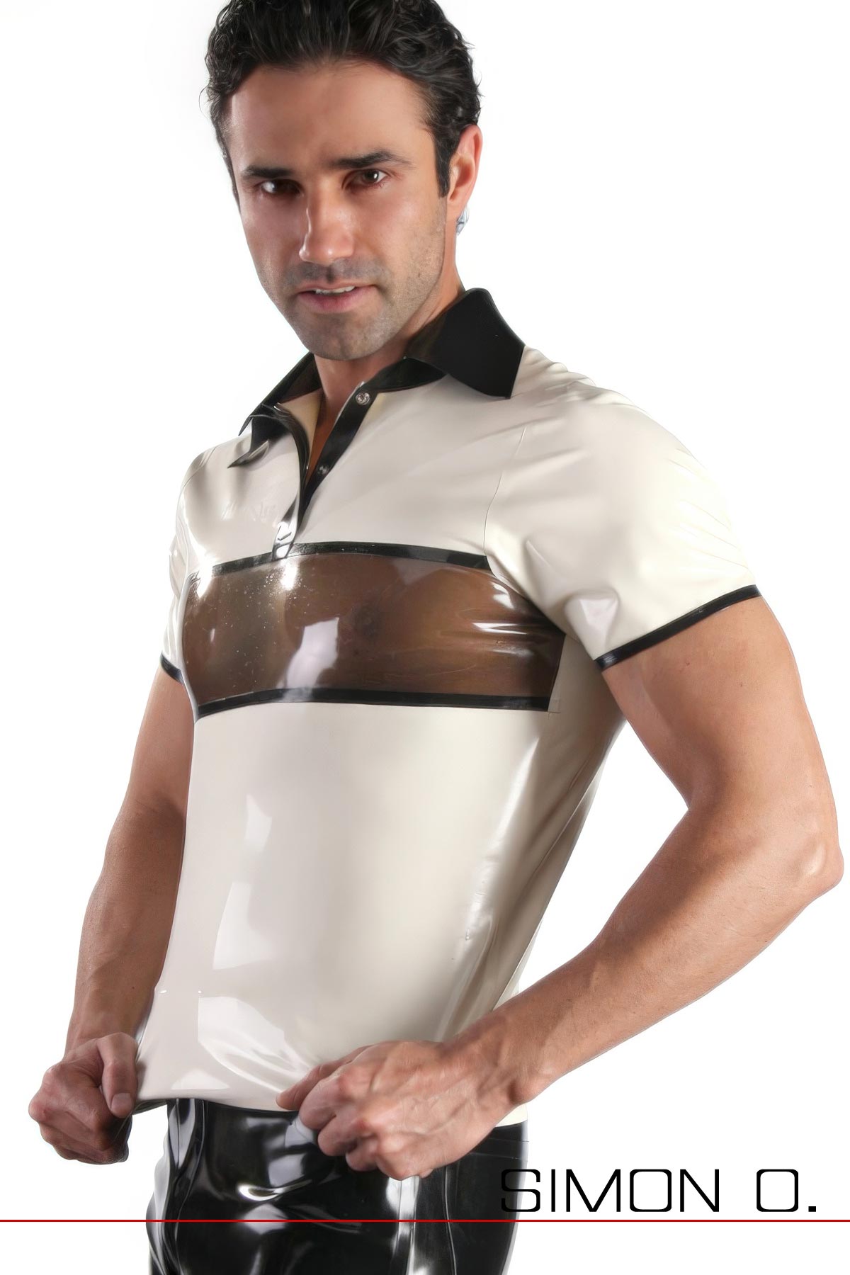 Ein Mann steht mit den Händen in den Hüften und trägt ein glänzendes weißes Poloshirt aus Latex mit kurzen Ärmeln, schwarzem Kragen und einem durchscheinenden braunen Streifen über der Brust.