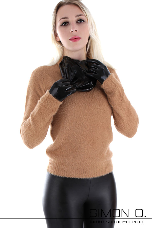 Latex unter Kleidung Eine Person in einem hellbraunen Pullover und Glanz Leggings holt eine Latex Maske unter der Kleidung hervor.