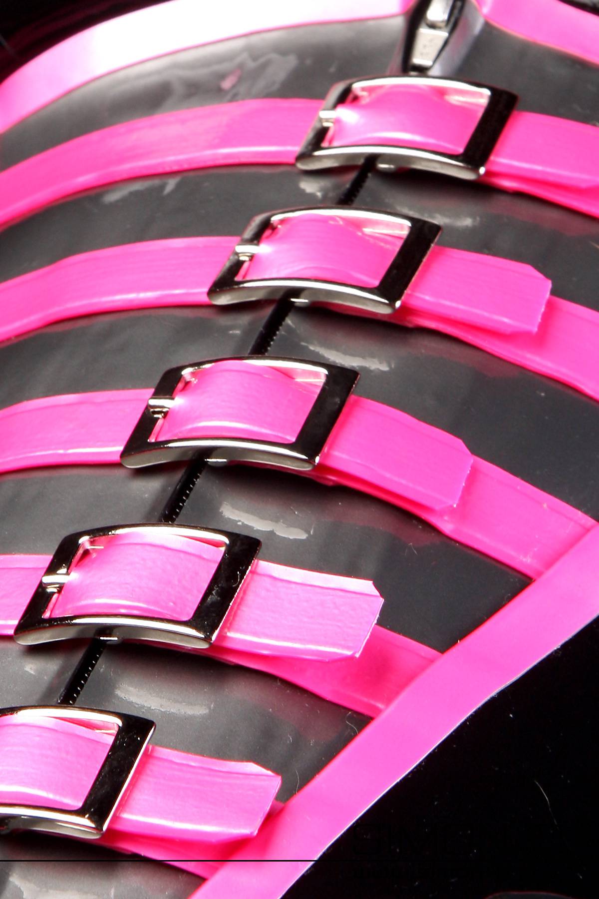 Latex corset with buckles Close-up of five shiny pink straps with silver buckles attached to a latex corset.