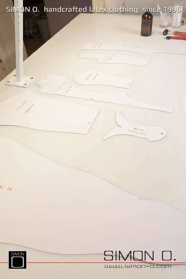 La production d'un catsuit en latex rose avec une partie transparente pour les jambes est montrée, en commençant par le découpage et le collage jusqu'au produit fini.