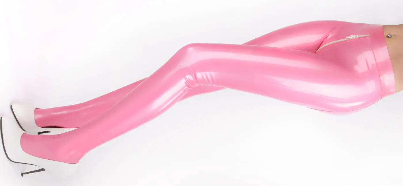 Eine Person trägt eine glänzend rosa Latex-Strumpfhose und weiße Stöckelschuhe, mit einem sichtbaren Bauchnabelpiercing.