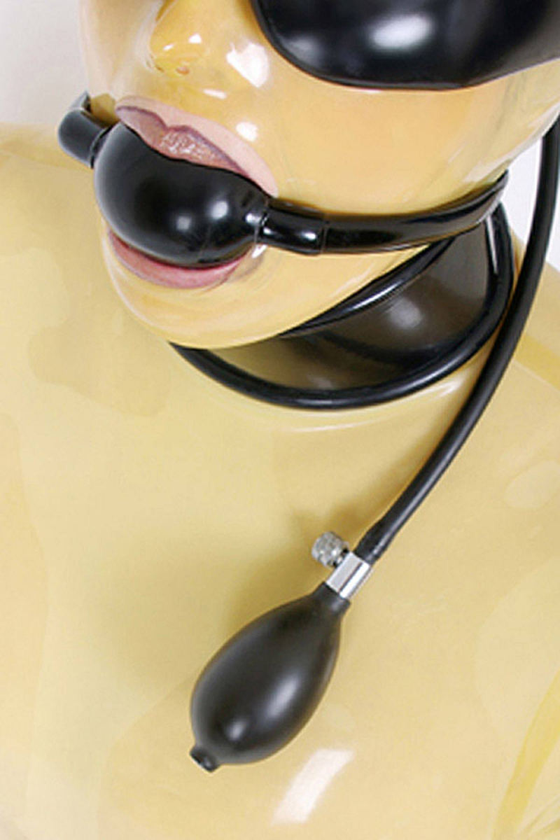 Ovaler Latex Knebel mit Befestigung Eine Frau mit transparenter Latex Maske hat einen schwarzen Knebel im Mund und trägt eine Augenbinde aus Latex