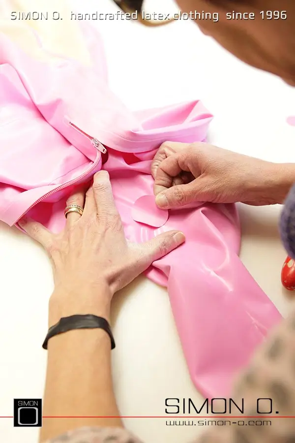 La production d'un catsuit en latex rose avec une partie transparente pour les jambes est montrée, en commençant par le découpage et le collage jusqu'au produit fini.
