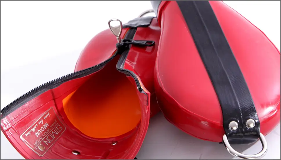 Latex Bondage-Fäußtlinge aus dickem roten Latex mit schwarzen Applikationen vor weißen Hintergrund.