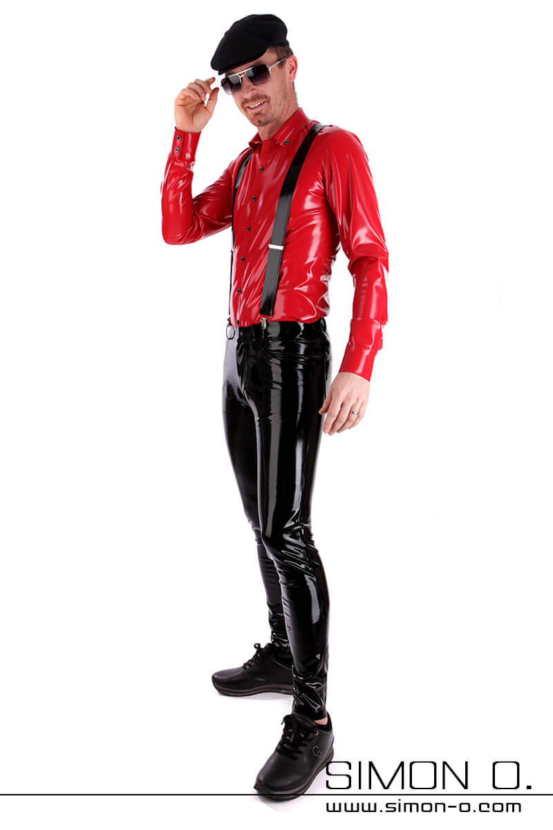 Herren Latex Hemd in rot Ein Mann in einem roten Herren-Latexhemd, einer schwarzen Latexhose mit Hosenträgern und einer Mütze posiert vor einem weißen Hintergrund.