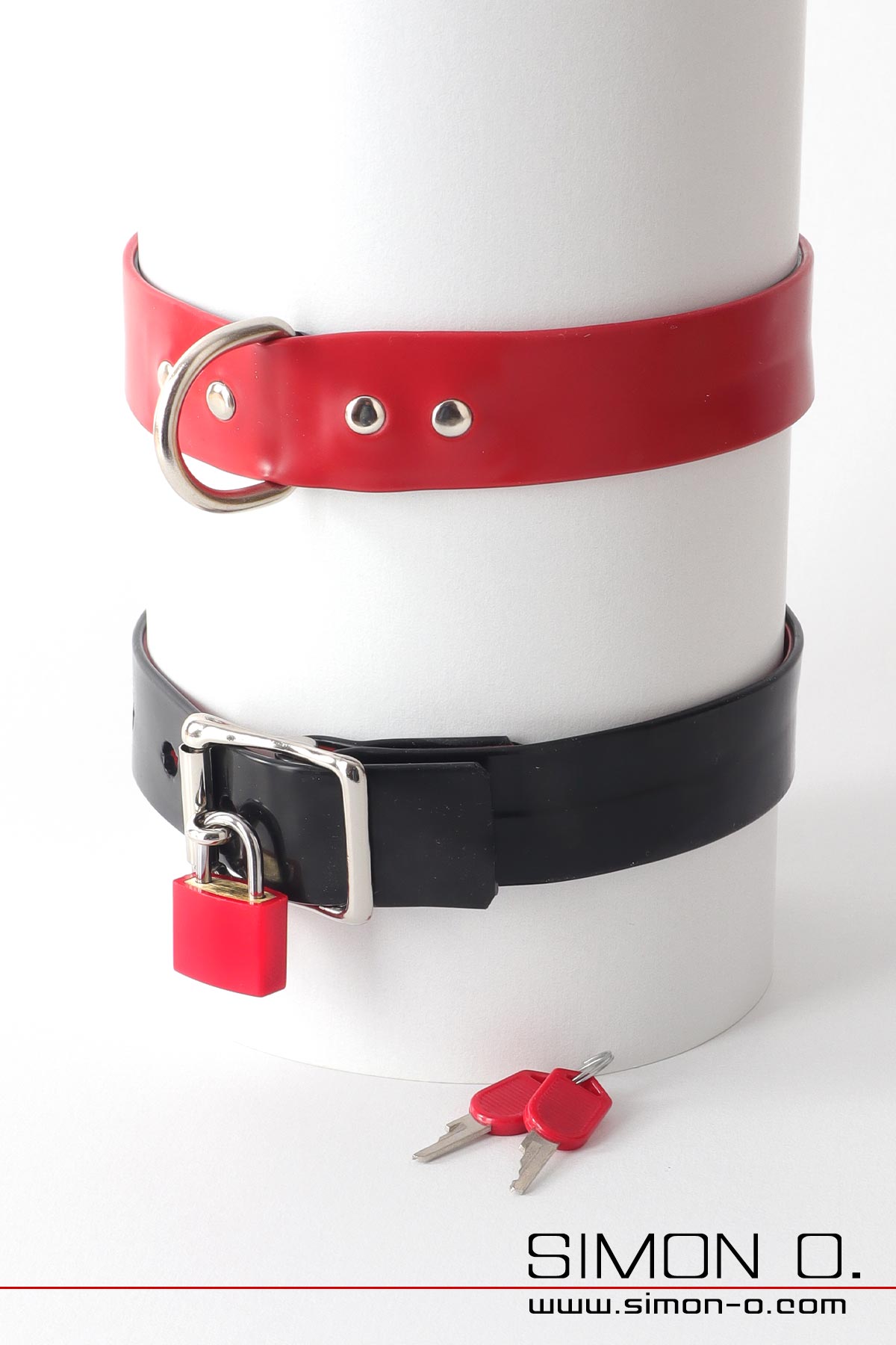 Latex collar in red and black with D-ring Latex Halsband in rot und schwarz mit D-Ring. Die Rückseite zeigt eine mit einem Vorhängeschloss absperrbare Schnalle.