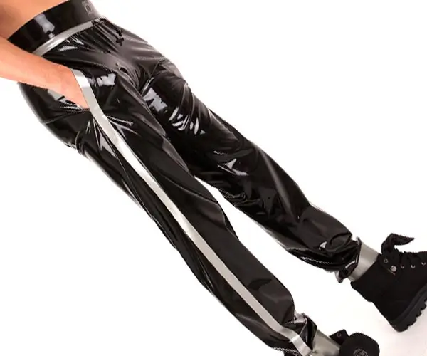 A gentleman wears latex jogging trousers with pockets in black with silver contrasting stripes.