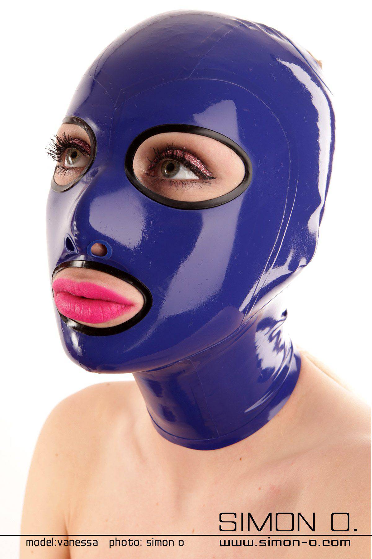 Sklaven Latex Maske in blau Eine  Frau mit einer glänzende blauen Latexmaske, die Kopf und Hals umhüllt und präzise Aussparungen für Augen und Mund aufweist, wodurch ein rätselhafter Reiz entsteht, der einem Sklavin würdig ist.