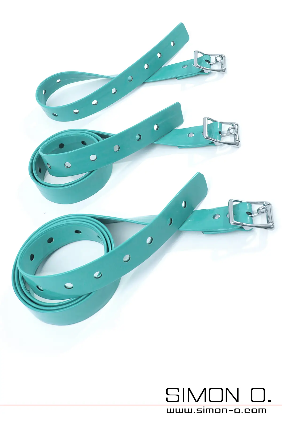 Drei jadegrüne Latex-Bondage Riemen im Set mit Löchern und einer Metallschnalle, aufgerollt auf weißem Hintergrund.