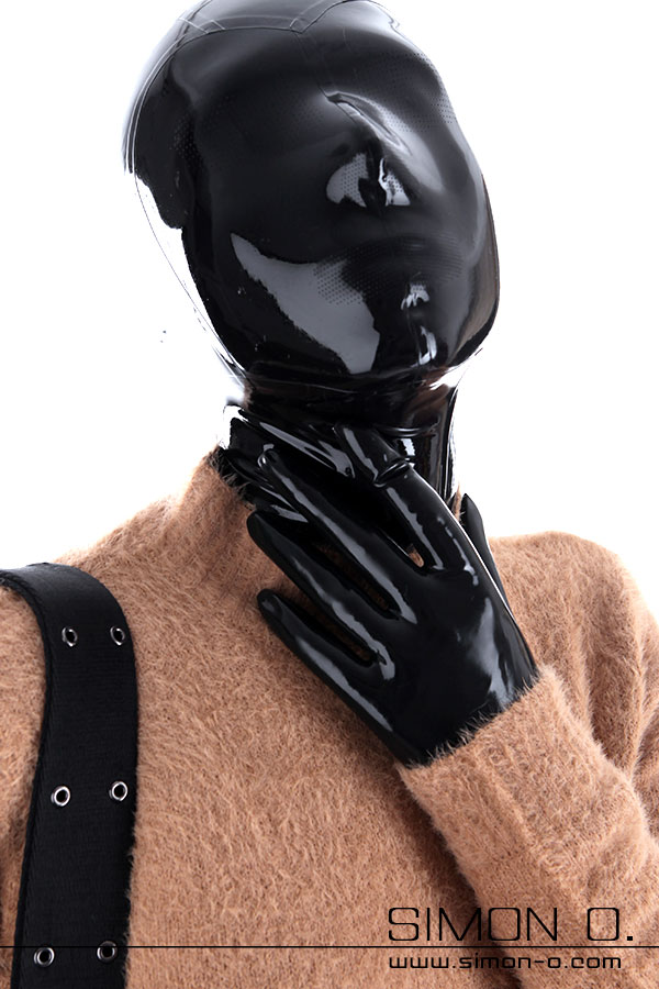 Latex outfit unter normaler Kleidung Eine Person trägt eine glänzende schwarze Latexmaske und Handschuhe, unter einen hellbraunen Pullover