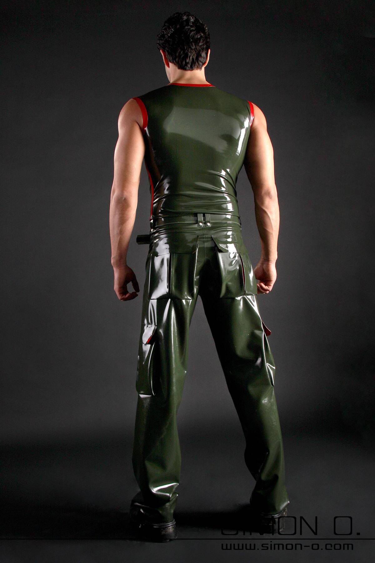 Men's Tank Top with Stripe One person is facing away, wearing a shiny dark green latex tank top and matching trousers against a dark background.