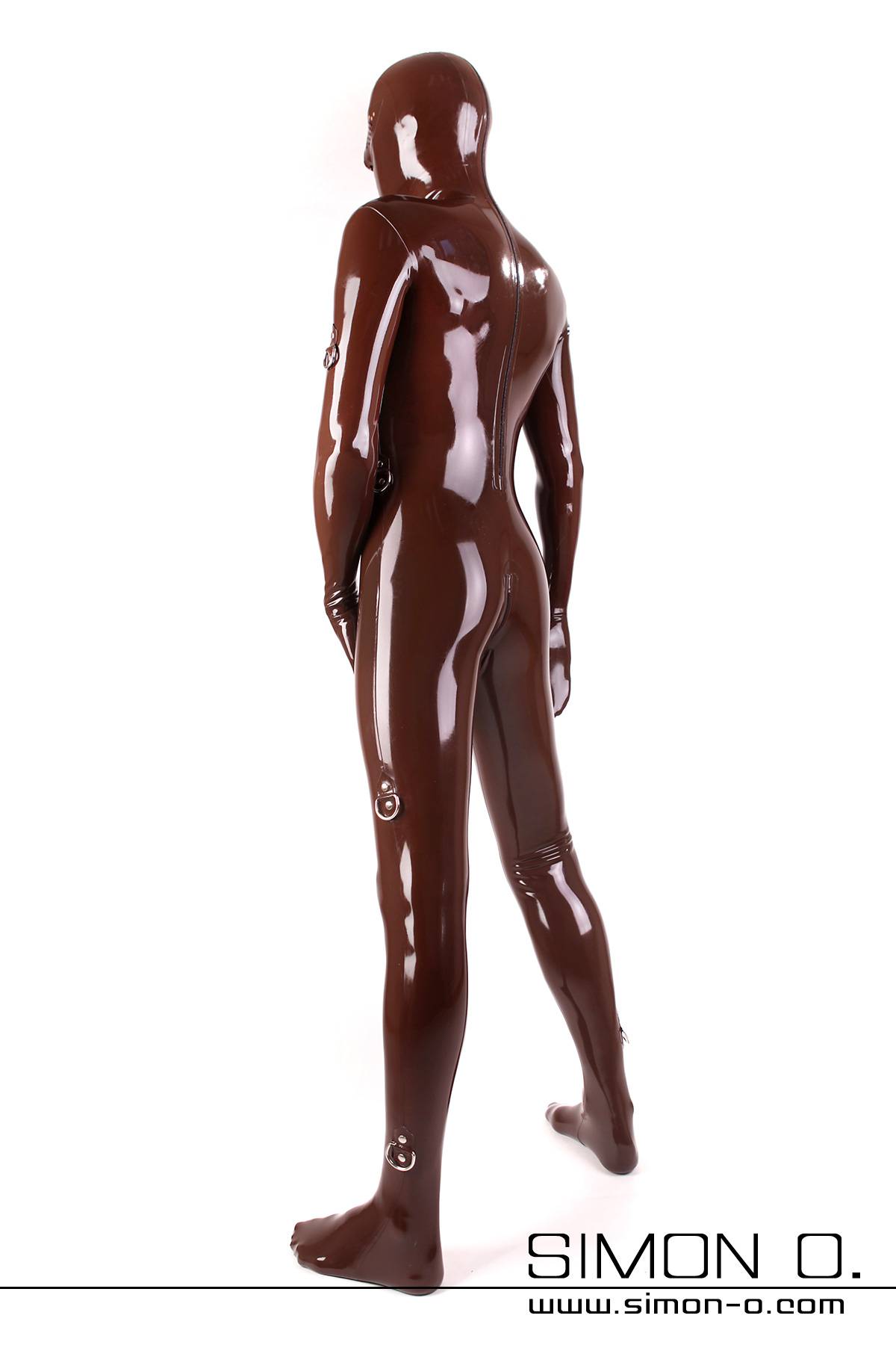 Latex Bondage Catsuit Herren Eine Person in einem glänzend braunen Herren-Latex-Bondage-Catsuit steht schräg und blickt abgewandt. Der Hintergrund ist weiß.