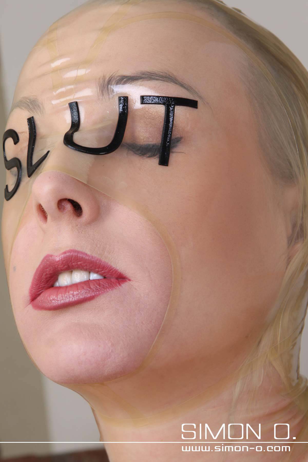 Latex hood with slut lettering Latex hood in transparent with SLUT writing in black for latex slave girls