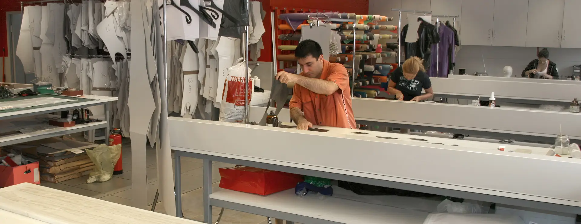 Une pièce avec des tables de travail où les ouvriers produisent des vêtements en latex.