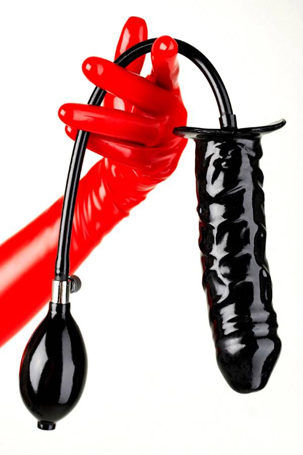 Latex dildo in black with pump held by one hand dressed with red latex gloves