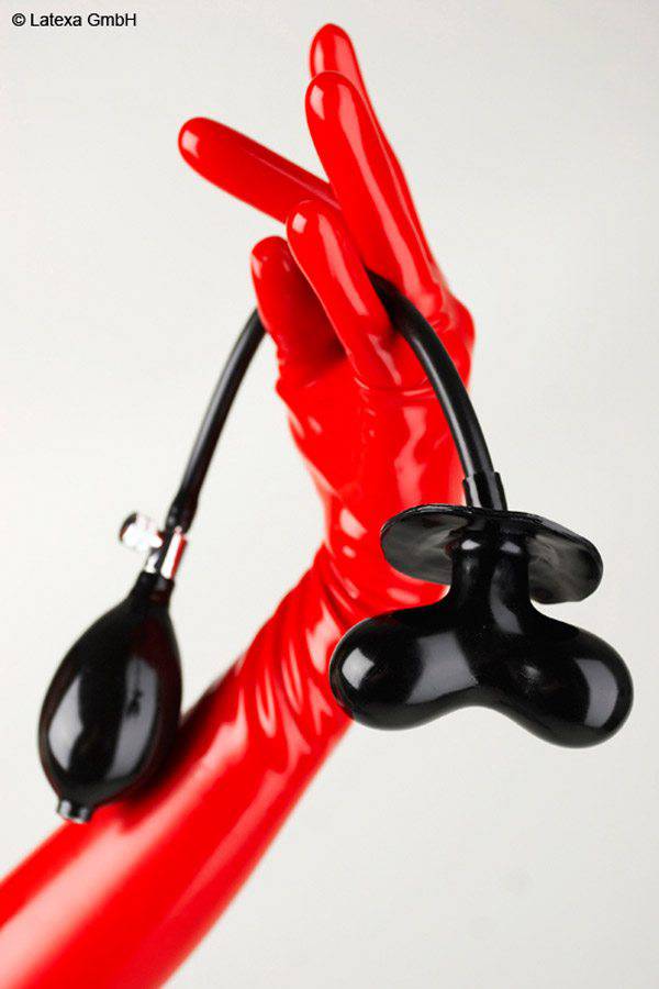 A hand with red latex glove holds a gag in black which is inflatable with a pump