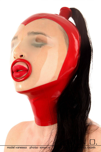 Slaves latex hood in red with mouth open and eyes closed with hairpiece in black