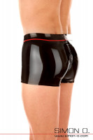 Preview: A man wears latex briefs in black with a red stripe on the waistband seen from behind