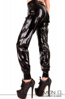 Preview: A woman wears shiny latex sweatpants with pockets seen from the side