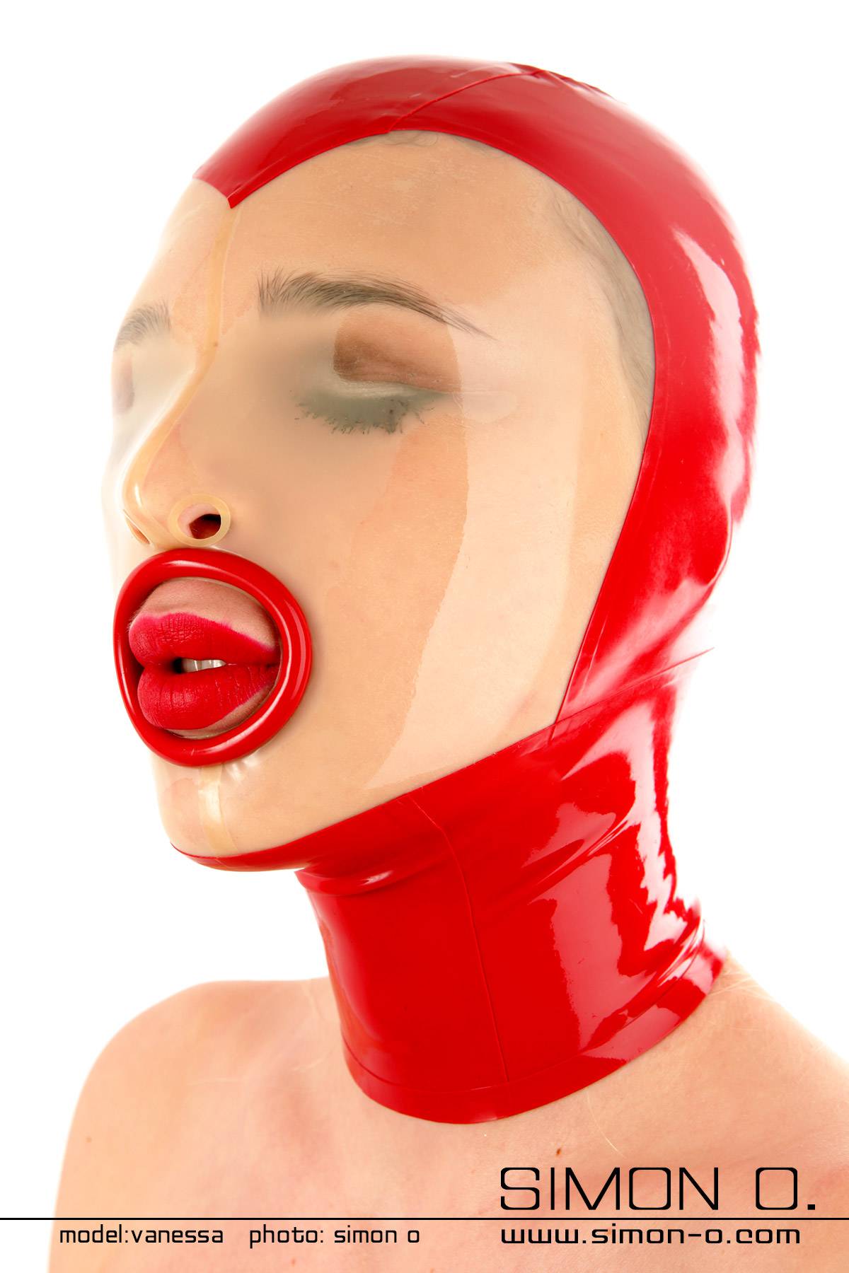 Black latex hood with transparent insert in the face area. Eyes closed and at the mouth there is a black ring