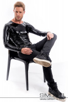 Vorschau: Ein Mann sitzt auf einen Sessel und trägt ein schwarzes langarm Latex Shirt mit Rundausschnitt mit einer schwarzen Jean