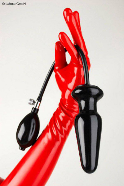 A hand with a red latex glove holds an inflatable anal plug with hose and hand pump.