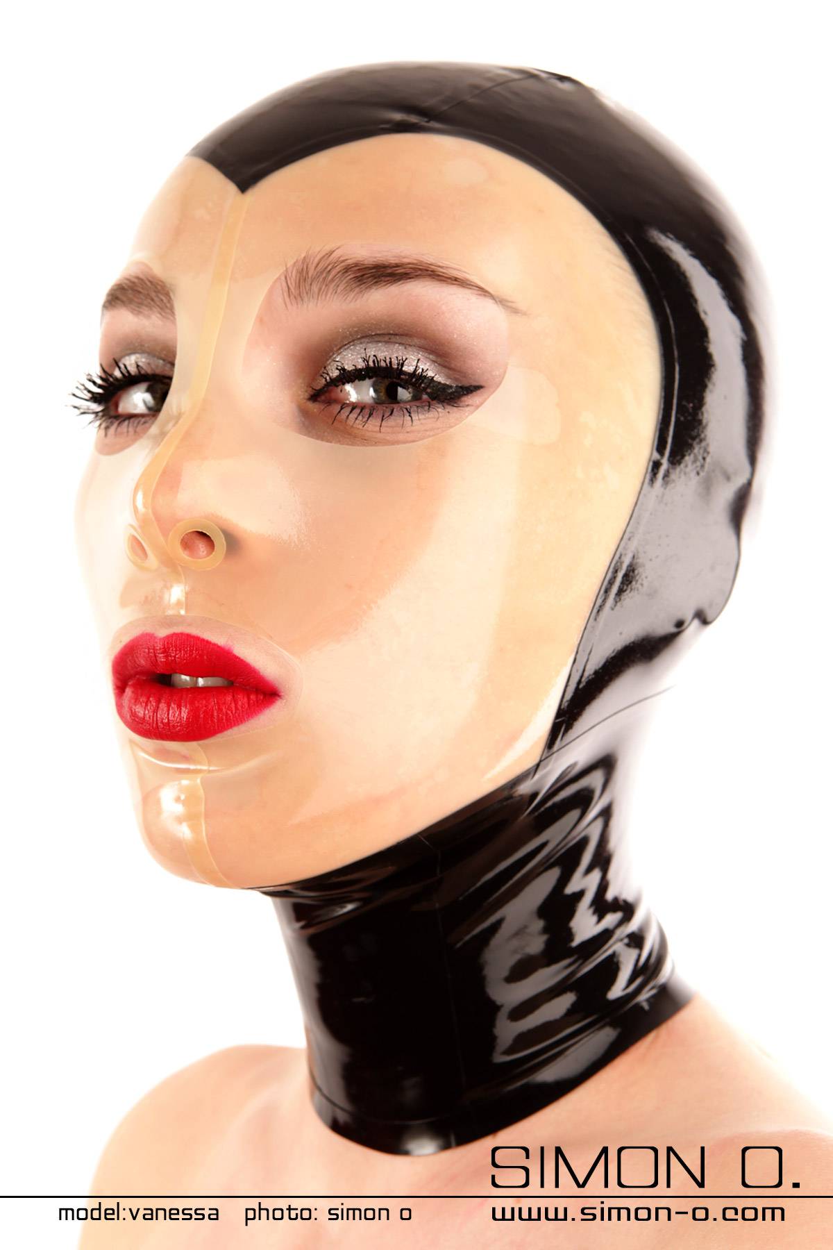 A woman wears a black latex hood with a transparent face panel